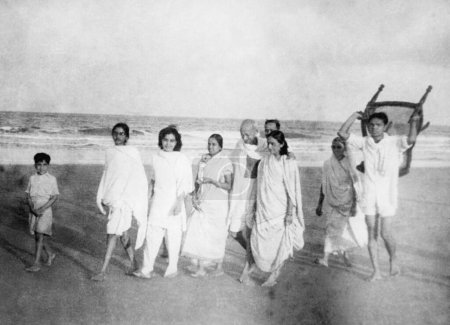 Téléchargez les photos : Mahatma Gandhi et d'autres marchant à Juhu Beach, Mumbai, mai 1944, Manu Gandhi, Sushila Nayar, Inde - en image libre de droit