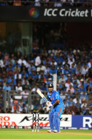 Téléchargez les photos : Capitaine indien, batteur M S Dhoni se prépare à jouer sa chance lors de la finale de la Coupe du monde ICC 2011 entre l'Inde et le Sri Lanka au stade Wankhede le 2 avril 2011 à Mumbai en Inde - en image libre de droit