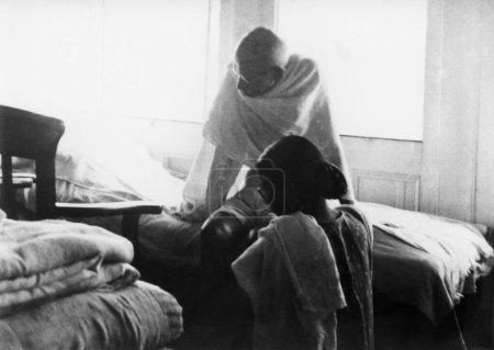 Foto de Mahatma Gandhi, sentado en una cama en el vapor en su camino a Bihar, 1947, Manu Gandhi, India - Imagen libre de derechos