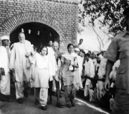 Foto de Khan Abdul Gaffar Khan; Mridulabehn Sarabai; Mahatma Gandhi y Manu Gandhi dejando un edificio en las zonas afectadas por los disturbios de Bihar; 1947; India - Imagen libre de derechos