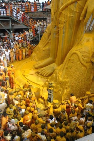 Téléchargez les photos : Pied de 58,8 pieds statue monolithique de saint jain Gomateshwara seigneur Bahubali recouvert de curcuma avec dans Mahamastakabhisheka cérémonie d'onction de la tête ; Sravanabelagola ; Karnataka ; Inde - en image libre de droit