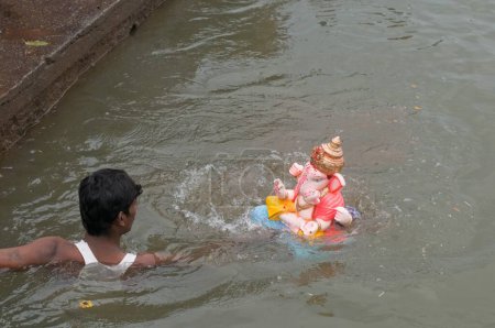 Téléchargez les photos : Homme libérant l'idole du Seigneur Ganesh Pune Maharashtra Inde Asie Sept 2011 - en image libre de droit