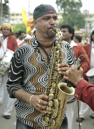 Téléchargez les photos : Janmashtami festival ou fête d'anniversaire du Seigneur Krishna procession de carnaval avec musicien de groupe musical avec saxophone avec une autre personne tenant le microphone pour l'amplification, Jabalpur, Madhya Pradesh, Inde - en image libre de droit