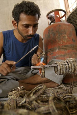 Foto de Hombre haciendo brazaletes de latón; Rajkot; Gujarat; India - Imagen libre de derechos