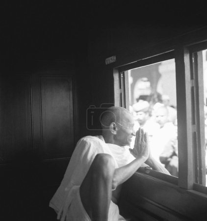 Téléchargez les photos : Mahatma Gandhi, saluant les gens par la fenêtre d'un train, 1940 - en image libre de droit