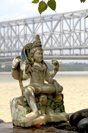 Foto de Estatua de dios Shiva en el puente Howrah (Rabindra Setu) en el fondo; Calcuta ahora Calcuta; Bengala Occidental; India - Imagen libre de derechos