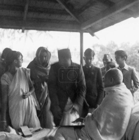 Foto de Abha Gandhi, Mahatma Gandhi con miembros de la familia Birla en Khadi Pratishthan, Sodepur, 24 Parganas, Calcuta, 1946, India - Imagen libre de derechos