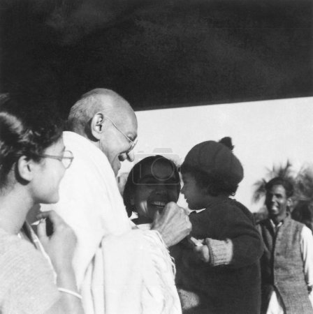 Téléchargez les photos : Abha Gandhi, Mahatma Gandhi et Sushila Nayar portant Rajiv Gandhi à Shantiniketan, 1945, Inde - en image libre de droit