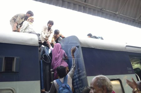 Téléchargez les photos : Homme tirant femme sur le toit entraîneur de train Jodhpur Rajasthan Inde Asie - en image libre de droit