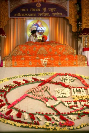 Foto de Un clérigo sij agita olas sobre el sagrado Guru Granth Sahib durante la celebración del 300º año de Consagración del Guru perpetuo Granth Sahib, Sachkhand Saheb Gurudwara, Nanded, Maharashtra, India - Imagen libre de derechos