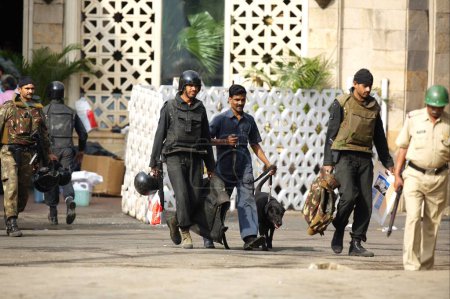 Téléchargez les photos : Gardiens de la sécurité nationale commandos NSG avec des chiens devant l'hôtel Taj Mahal après avoir tué des terroristes, Bombay Mumbai, Maharashtra, Inde - en image libre de droit