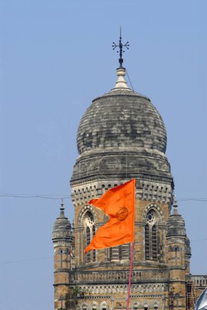 Foto de Bandera de color escarlata frente a la cúpula de Mumbai Municipal Corporation edificio om símbolo sagrado impreso en ella Azad Maidan; Bombay Mumbai; Maharashtra; India - Imagen libre de derechos