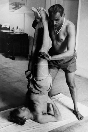 Foto de Celebrado violinista Yehudi Menuhin siendo enseñado yoga por eminente profesor de yoga BKS Iyenger, Nueva Delhi 1970 - Imagen libre de derechos