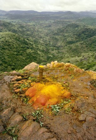 Einer der Orte auf dem Berg, von dem angenommen wird, dass er von Khandoba besucht wird, wird von den Anhängern mit grünen Blättern und Kurkumapulver verehrt, Jejuri, Maharashtra, Indien 