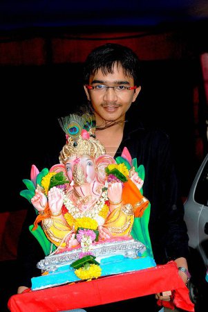 Foto de Boy carrying Lord Ganesha Idol immersion, Mumbai, Maharashtra, India, Asia, MR#364 - Imagen libre de derechos