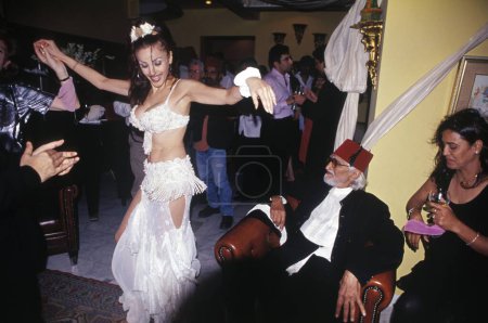 Foto de M F Hussain disfruta de los movimientos de la bailarina del vientre en la fiesta de cumpleaños India Asia - Imagen libre de derechos
