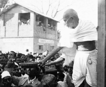 Foto de Mahatma Gandhi, recaudando donaciones para el Fondo Harijan con una cesta en la mano en una estación de tren en su camino a Assam, enero 1946 - Imagen libre de derechos