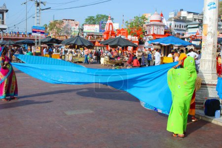 Téléchargez les photos : Femmes pèlerines séchant les chiffons, Hardwar, Uttar Pradesh, Inde - en image libre de droit