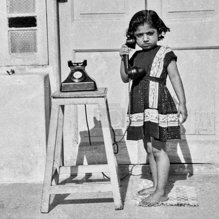 Photo for Old vintage 1900s black and white picture of Indian girl early black no dial telephone without dial India 1940s - Royalty Free Image
