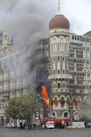 Photo for Fire inside the Taj Mahal hotel and Fire Brigade taking position outside the hotel ; after terrorist attack by Deccan Mujahedeen on 26th November 2008 in Bombay Mumbai ; Maharashtra ; India - Royalty Free Image