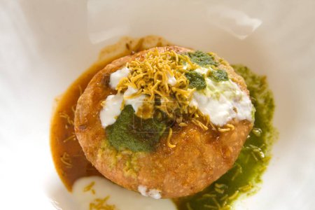 Foto de Snack indio frito shahi khasta kachori chaat con cilantro verde de yogur y chutney de tamarindo con sev servido en bowl 23-April-2010 - Imagen libre de derechos