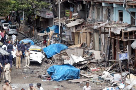 Téléchargez les photos : Des policiers inspectent le site de l'explosion à Zaveri Bazaar dans la zone occupée de Kalbadevi ; Bombay Mumbai, Maharashtra, Inde Le 26 août 2003 - en image libre de droit