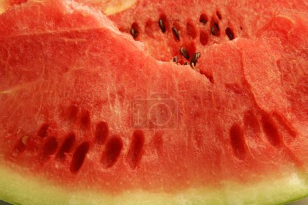 Fruits ; Cut piece of watermelon showing watery red pulp and black seeds ; Pune; Maharashtra; India