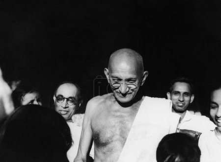 Téléchargez les photos : Mahatma Gandhi et Pyarelal Nayar l, qui porte sa nièce Nandini à l'ashram de Sevagram, août 1944 - en image libre de droit