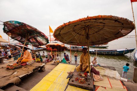 Téléchargez les photos : Prêtre assis sous un énorme parapluie à Dashashwamedh Ghat sur la rivière Ganga Ganges, Varanasi, Banaras, Benaras, Kashi, Uttar Pradesh, Inde - en image libre de droit