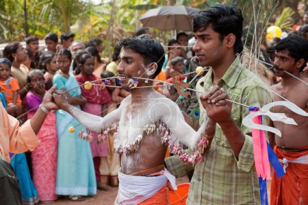 Photo for Man piercing spike through cheeks discharging vow in Thaipusam festival, Kerala, India - Royalty Free Image