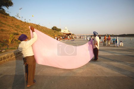 Foto de Devotos sij secado tradicional de 6 metros de largo casco o en 15 km de largo Ghat del río Godavari después del baño sagrado, Nanded, Maharashtra, India - Imagen libre de derechos