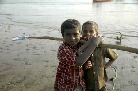 Foto de Dos niños indios de pescadores en la playa antes de zarpar para pescar, Bombay ahora Mumbai, India - Imagen libre de derechos
