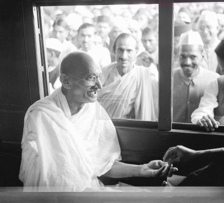 Foto de Mahatma Gandhi, recibiendo una donación en el compartimiento del tren Acharya Kripalani y Radhakrishna Bajaj están mirando por la ventana, 1940 NO MR - Imagen libre de derechos