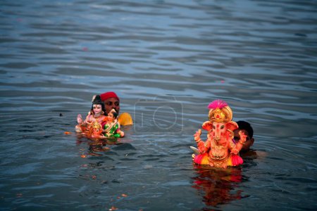 Photo for Idols of Lord Ganesha ganpati Hindu deity being immersed in Powai lake ; Bombay Mumbai ; Maharashtra ; India - Royalty Free Image