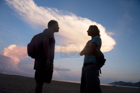 Foto de Dos figuras de silueta humana hablando; Playa de Palolem; Goa; India - Imagen libre de derechos