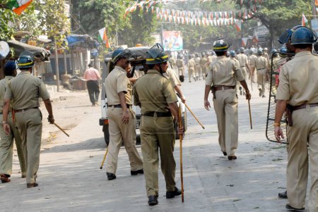 Téléchargez les photos : Des policiers patrouillent lorsque des émeutiers cassent des vitres de véhicules à Bhandup après que la communauté dalit a eu recours à des manifestations violentes, Bombay maintenant Mumbai, Maharashtra, Inde - en image libre de droit