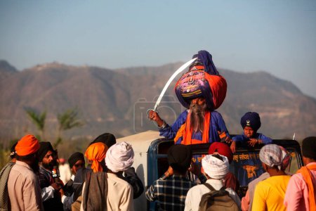 Téléchargez les photos : Guerrier nihang ou sikh en pagdi ou coiffure avec épée pendant les célébrations Hola Mohalla à Anandpur sahib dans le district de Rupnagar, Punjab, Inde - en image libre de droit