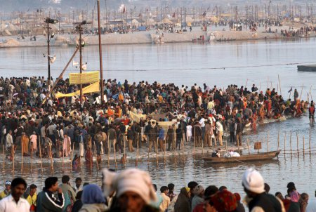 Foto de Peregrinos o devotos se reúnen en la confluencia del Ganges, Yamuna y los míticos ríos Saraswati para darse un baño sagrado durante el Ardh Kumbh Mela, uno de los festivales religiosos más grandes del mundo en Allahabad, Uttar Pradesh, India. - Imagen libre de derechos
