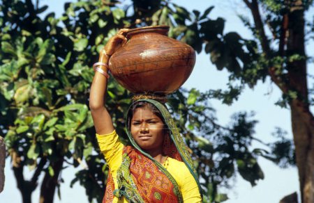 Foto de Mujer llevando maceta con agua - Imagen libre de derechos