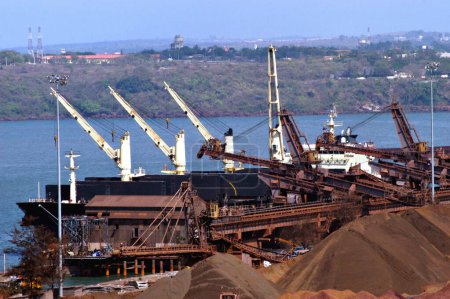 Foto de Transporte marítimo; mineral de hierro a la espera de ser cargado en buques graneleros en el muelle lleno a capacidad Mormugao Port Trust en Vasco en el suroeste de Goa; India - Imagen libre de derechos