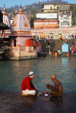 Téléchargez les photos : Homme et prêtre à Har Ki Pauri, Haridwar, Uttar Pradesh, Inde - en image libre de droit