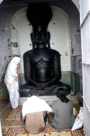 Foto de Devotos sentados frente a la estatua de Dios, Chamar Leni, Nashik, Maharashtra, India - Imagen libre de derechos