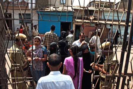 Téléchargez les photos : Les électeurs présentent leur carte de vote ou leur bulletin de vote au bureau de vote Bombay Mumbai, Maharashtra, Inde 30, avril 2009 - en image libre de droit