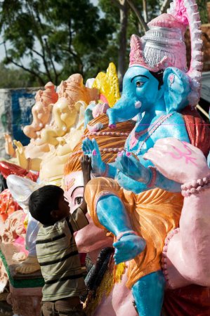 Téléchargez les photos : Garçon debout à la statue du dieu ganesh et Shiva, Rajasthan, Inde - en image libre de droit
