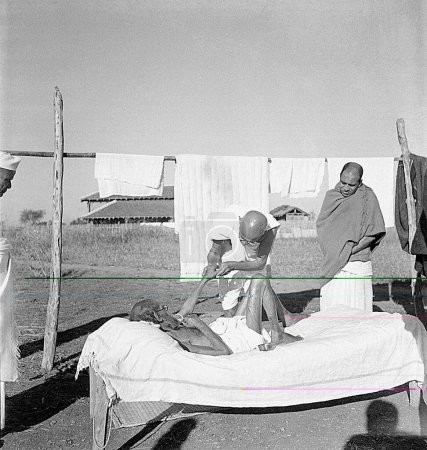 Foto de Mahatma Gandhi atendiendo al leproso paciente estudioso sánscrito Parchure Shastri en el Ashram Sevagram, 1940 - Imagen libre de derechos