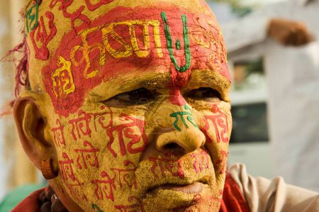 Téléchargez les photos : Prêtre écrivant radhe krishna sur le visage par pâte de bois de santal, uttar pradesh, Inde, Asie - en image libre de droit