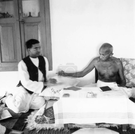 Téléchargez les photos : Mahatma Gandhi et Shriman Narayan à sa résidence Jeevan Kutir à Wardha, 1945, Inde - en image libre de droit
