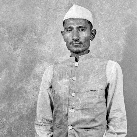 Photo for Old vintage 1900s black and white studio portrait of Indian man wearing white jacket topi cap India 1940s - Royalty Free Image