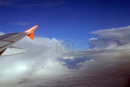 Aerial view of clouds and aircraft wing 