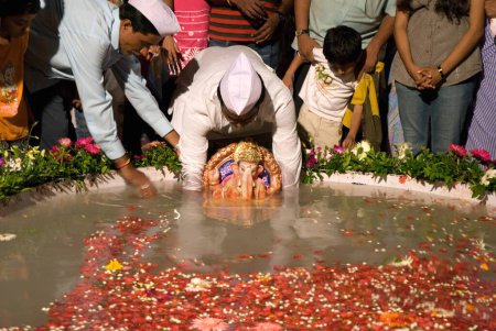 Téléchargez les photos : Les gens plongeant idole de lord ganesh dans l'étang, Bombay Mumbai, Maharashtra, Inde - en image libre de droit